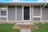 Charming entryway of a modern apartment with a sleek black door and inviting front porch.