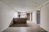 Contemporary open-concept kitchen with sleek cabinetry and modern appliances, leading to a spacious living area with elegant wood flooring.