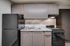 Modern kitchen with sleek black appliances, elegant cabinetry, and a stylish granite countertop.