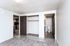 Spacious bedroom featuring soft carpet, built-in closet, and en-suite bathroom with wooden accents.