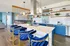 Sleek kitchen with blue cabinets, white countertops, and elegant open shelving.
