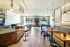 Modern entertainment lounge with a bar, pool table, and seating area, featuring stylish lighting.