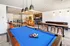 Inviting recreational lounge featuring a billiards table, high-top seating, and a cozy bar area.