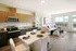 Bright open-concept kitchen and living room with ocean view, featuring modern cabinetry and elegant dining setup.