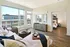 Bright and spacious living room with a large window view, stylish furniture, and access to a cozy bedroom.