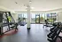 Bright, modern fitness center with cardio machines, weights, and large windows overlooking a scenic view.
