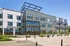 Contemporary apartment building facade featuring large windows and stylish balconies under clear blue skies.