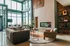 Chic living room with large windows, modern furniture, and an elegant fireplace accentuating a stylish design.