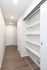 Modern apartment entryway featuring sleek shelving and elegant wood flooring.