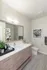 Modern bathroom with elegant vanity, sleek chrome fixtures, and tasteful artwork.