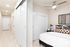 Modern apartment interior showcasing a bright hallway leading to a cozy bedroom with stylish decor and contemporary ceiling fan.