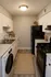 Bright and modern apartment kitchen with sleek black appliances, elegant tile backsplash, and stylish cabinetry.