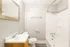 Elegant bathroom with modern fixtures, featuring a sleek vanity, stylish mirror, and a soothing bathtub.