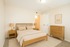 Inviting bedroom featuring elegant wooden furniture, soft lighting, and a soothing neutral palette.