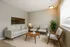 Bright and inviting living room with modern gray furniture, large window, and elegant decor creating a cozy ambiance.