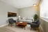 Modern living room with sleek gray sofa, stylish chairs, and warm natural light highlighting a cozy, inviting atmosphere.