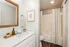 Bright and inviting bathroom with modern fixtures, framed mirror, elegant countertop, and cozy decor for a refreshing atmosphere.