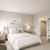 Elegant bedroom with plush beige bedding, stylish bedside lamps, and a serene palm tree artwork, exuding a peaceful ambiance.