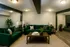Inviting living room with plush green sofas, elegant lighting, and chic decor, perfect for relaxation and entertainment.