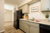 Charming kitchen with modern farmhouse decor, featuring sleek cabinetry, black appliances, and elegant wood flooring.