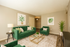 Elegant living room showcasing modern green velvet furniture, chic wall art, and cozy decor for a stylish and inviting atmosphere.