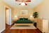Inviting bedroom with elegant wooden furniture, vibrant green bedding, and modern decor, exuding comfort and warmth.