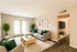 Inviting living room with modern gray sofas, vibrant green accents, and elegant decor, featuring abundant natural light through large patio doors.