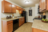 Charming kitchen with warm wood cabinets, sleek countertops, and modern appliances, ideal for culinary enthusiasts.