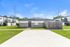 Bright and welcoming single-story apartment with modern facade, nestled in a well-maintained neighborhood with lush green lawns.