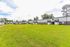 Expansive communal lawn surrounded by charming two-story apartments, perfect for relaxing outdoor living.