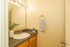 Charming bathroom with a sleek vanity, large mirror, and elegant lighting, featuring tasteful decor and modern fixtures.