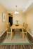 Inviting dining area with a cozy wooden table, green cushioned chairs, and elegant decor, perfect for family gatherings.