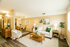 Elegant living room with cozy cream sofa, chic d&eacute;cor, and spacious dining area in an inviting apartment setting.
