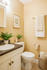 Charming bathroom with elegant fixtures, fresh greenery, and cozy towel accents.