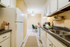 Cozy and modern kitchen with sleek countertops, white appliances, and a charming dining area in a bright, inviting atmosphere.