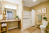 Bright and inviting bathroom featuring a modern vanity with granite countertop, elegant lighting, and decorative plants, perfect for a relaxing atmosphere.