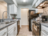 Kitchen with vinyl floors, white cabinets, black appliances, granite countertops