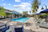 expansive pool and sundeck surrounded by trees with an orange cabana area