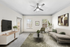 Living room with couch, TV, coffee table, and ceiling fan