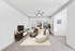 Living room with couch, TV, coffee table, and ceiling fan