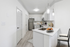 Vinyl floors, stainless-steel appliances, white quartz countertop, and pendant lighting.