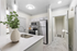Vinyl floors, stainless-steel appliances, white quartz countertop, and pendant lighting.