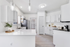 Vinyl floors, stainless-steel appliances, white quartz countertop, and pendant lighting.