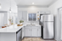 Vinyl floors, stainless-steel appliances, white quartz countertop, and pendant lighting.