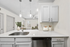 Vinyl floors, stainless-steel appliances, white quartz countertop, and pendant lighting.