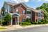 Exterior of brick apartment building with trees and sidewalk