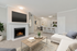 Carpeted living space with couch, chair, flat-screen TV, and fireplace