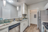 Kitchen with vinyl floors, stainless-steel appliances, granite countertop, and pendant lighting