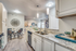 Kitchen with vinyl floors, stainless-steel appliances, granite countertop, and pendant lighting