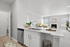 Modern kitchen featuring vinyl flooring, stainless-steel appliances, and a white quartz countertop
